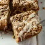 A square of the Apple Cider Coffee Cake Recipe showing the gorgeous cream cheese swirl layer inside the apple cider spiced crumb with golden streusel topping