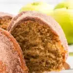 A slice of Apple Cider Doughnut Cake showing the moist warm apple cider spiced crumb with gorgeous cinnamon sugar coating on a white plate