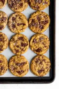 Chewy Pumpkin Chocolate Chip Cookie golden thick fall cookies with chocolate chips and flaky sea salt on a white plate on marble