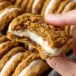 Close-up of an Oatmeal Sandwich Cookie showing the chewy rolled oat cookie with the gorgeous cream cheese cinnamon filling visible from the side