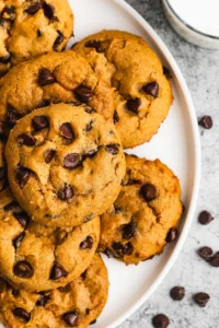 Pumpkin Chocolate Chip Cookie soft cream cheese fall cookies with cinnamon-pumpkin sugar coating and mini chocolate chips on a white plate on marble