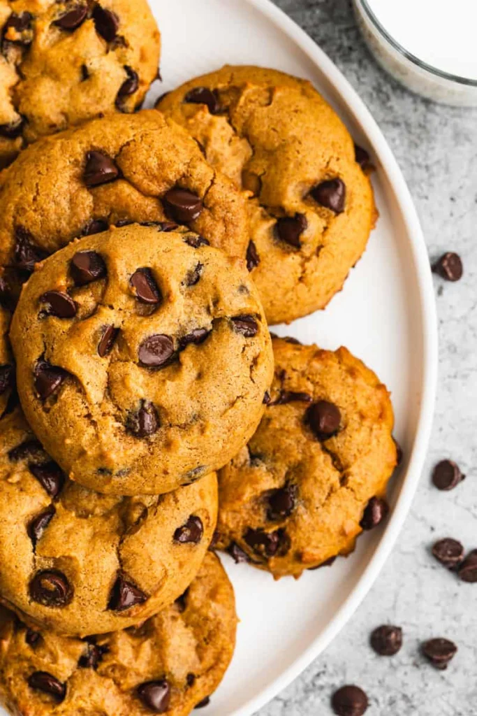 Home 4 Pumpkin Chocolate Chip Cookie soft cream cheese fall cookies with cinnamon-pumpkin sugar coating and mini chocolate chips on a white plate on marble